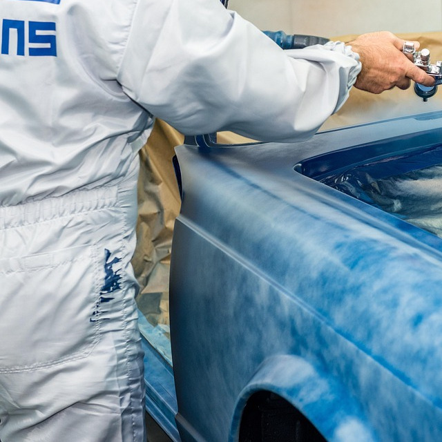 auto body painter spraying car